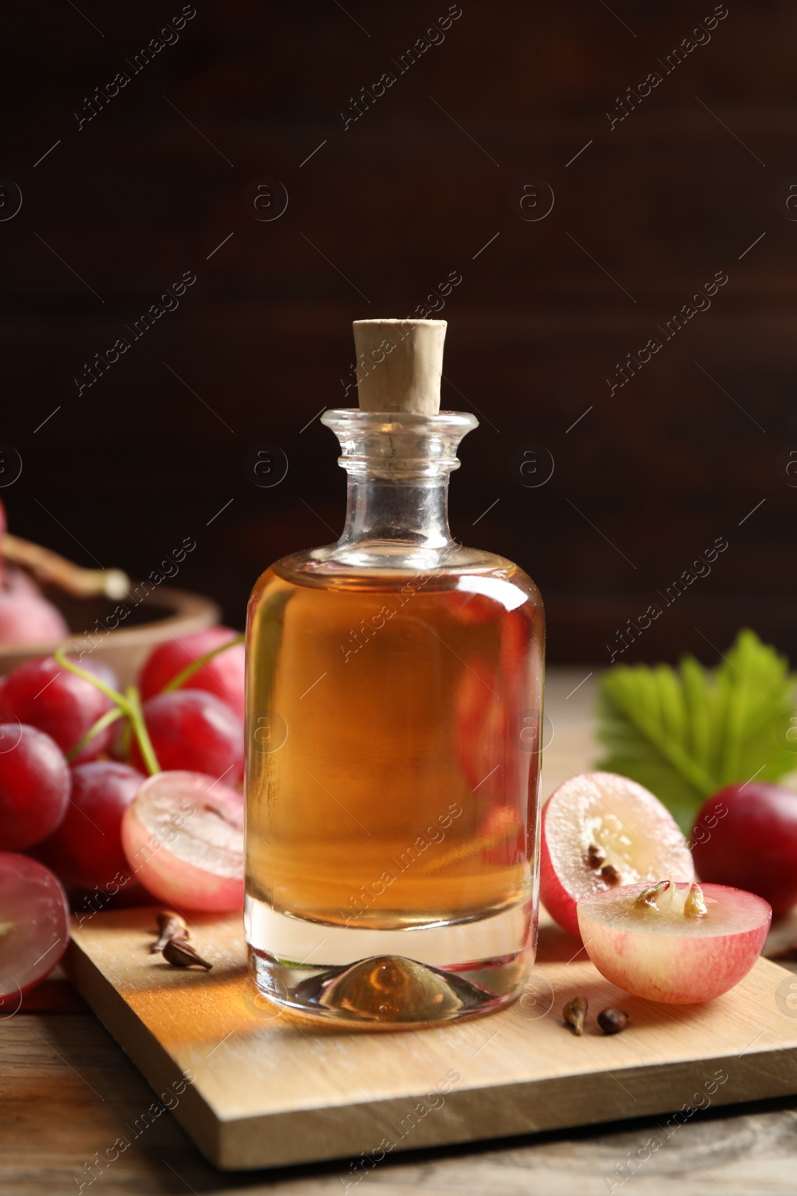 Photo of Bottle of natural grape seed oil on wooden table. Organic cosmetic