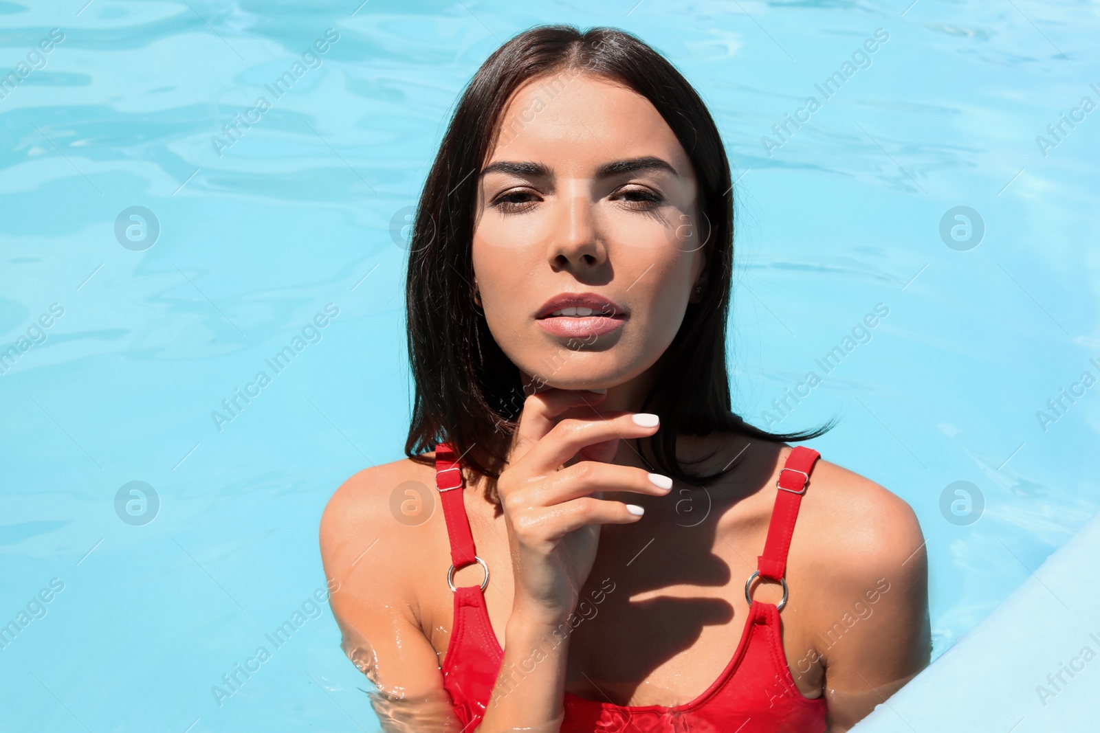 Image of Portrait of beautiful young woman in swimming pool