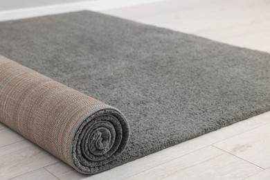 Photo of Rolled grey carpet on floor in room, closeup