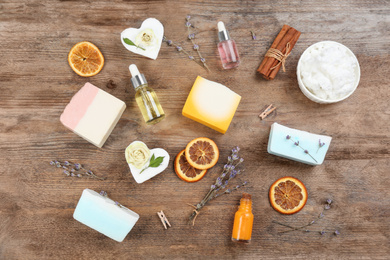 Photo of Flat lay composition with natural handmade soap and ingredients on wooden table