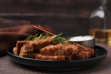 Photo of Crispy rusks with rosemary and sauce on grey table