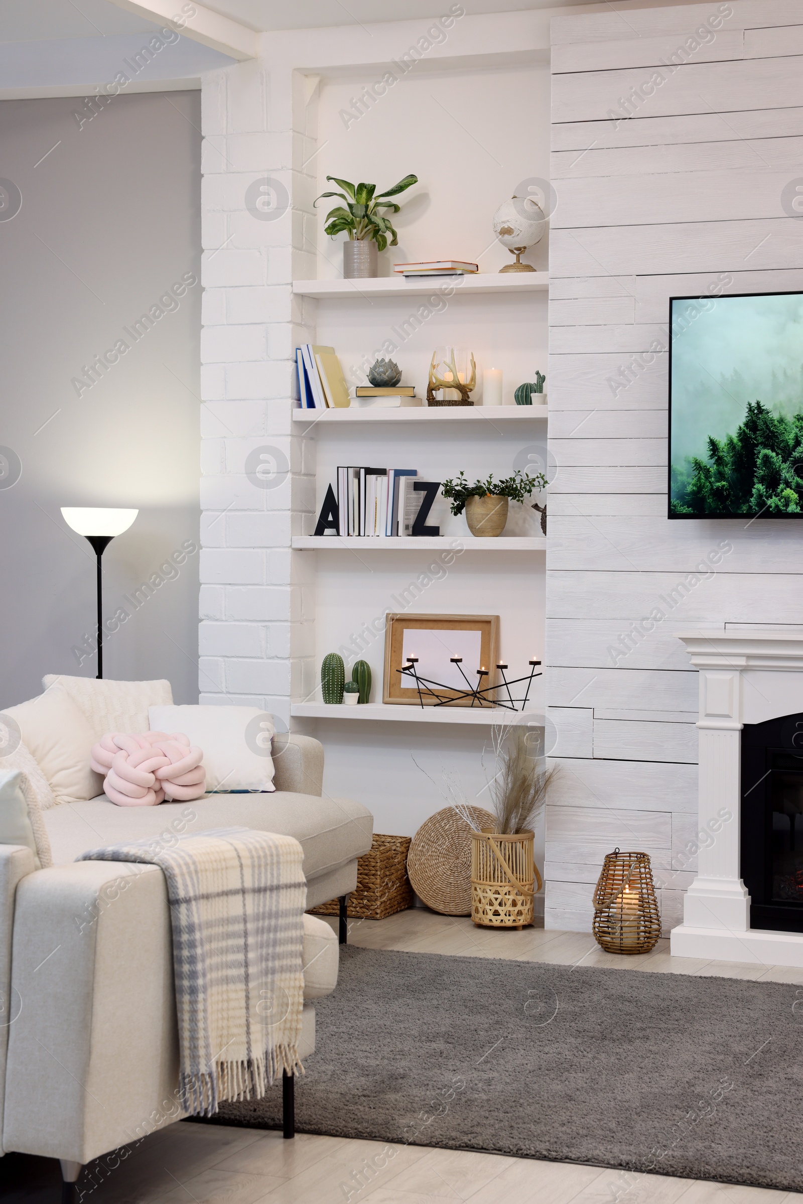 Photo of Cozy living room interior with comfortable sofa and decorative fireplace