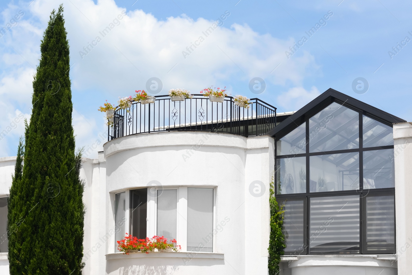 Photo of Balcony decorated with beautiful flowers on sunny day