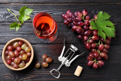 Flat lay composition with fresh ripe juicy grapes and wine on dark wooden table