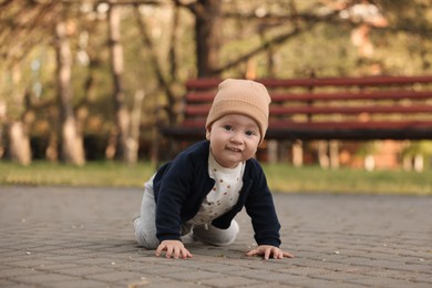 Photo of Learning to walk. Little baby crawling in park