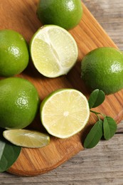 Photo of Fresh ripe limes on wooden table, top view