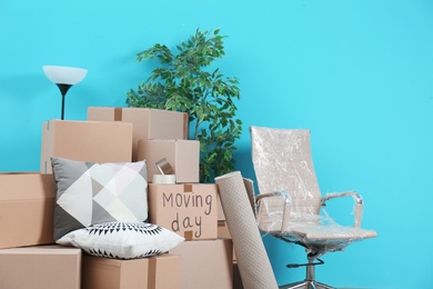 Cardboard boxes and household stuff in empty room. Moving day