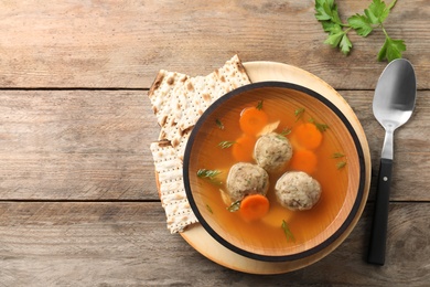 Flat lay composition with Jewish matzoh balls soup on wooden table. Space for text