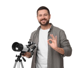 Photo of Happy astronomer with telescope showing ok gesture on white background
