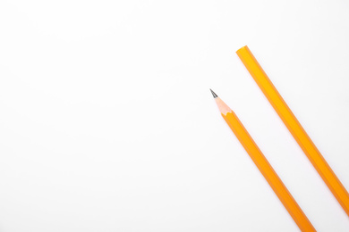 Photo of Pencil with point and unsharpened one on background white, top view. Space for text