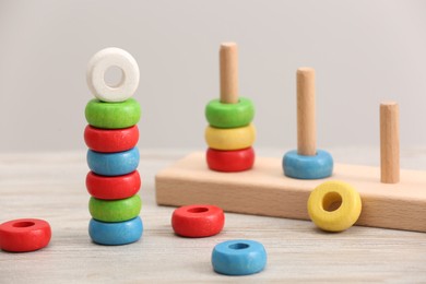 Educational toy for motor skills development. Stacking and counting game pieces on light wooden table