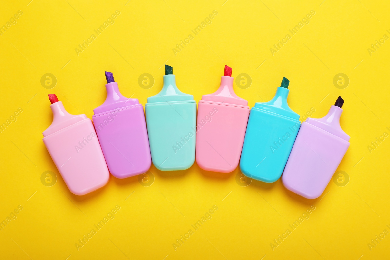 Photo of Many colorful markers on yellow background, flat lay