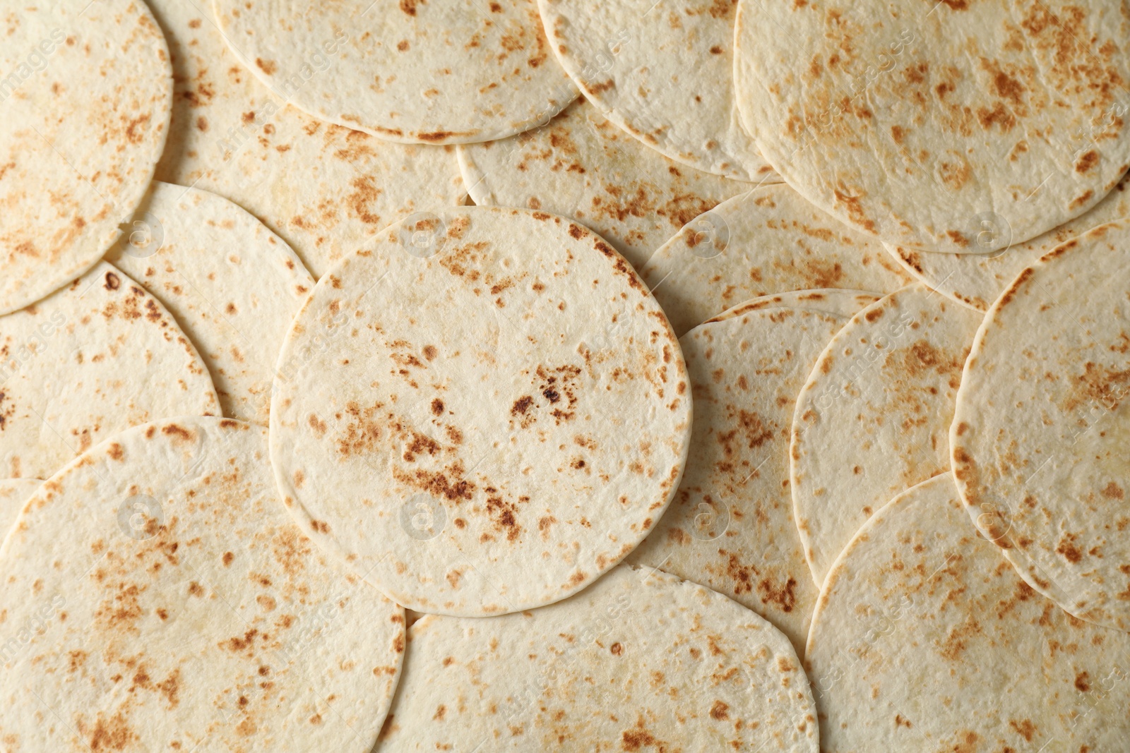 Photo of Many tasty homemade tortillas as background, top view