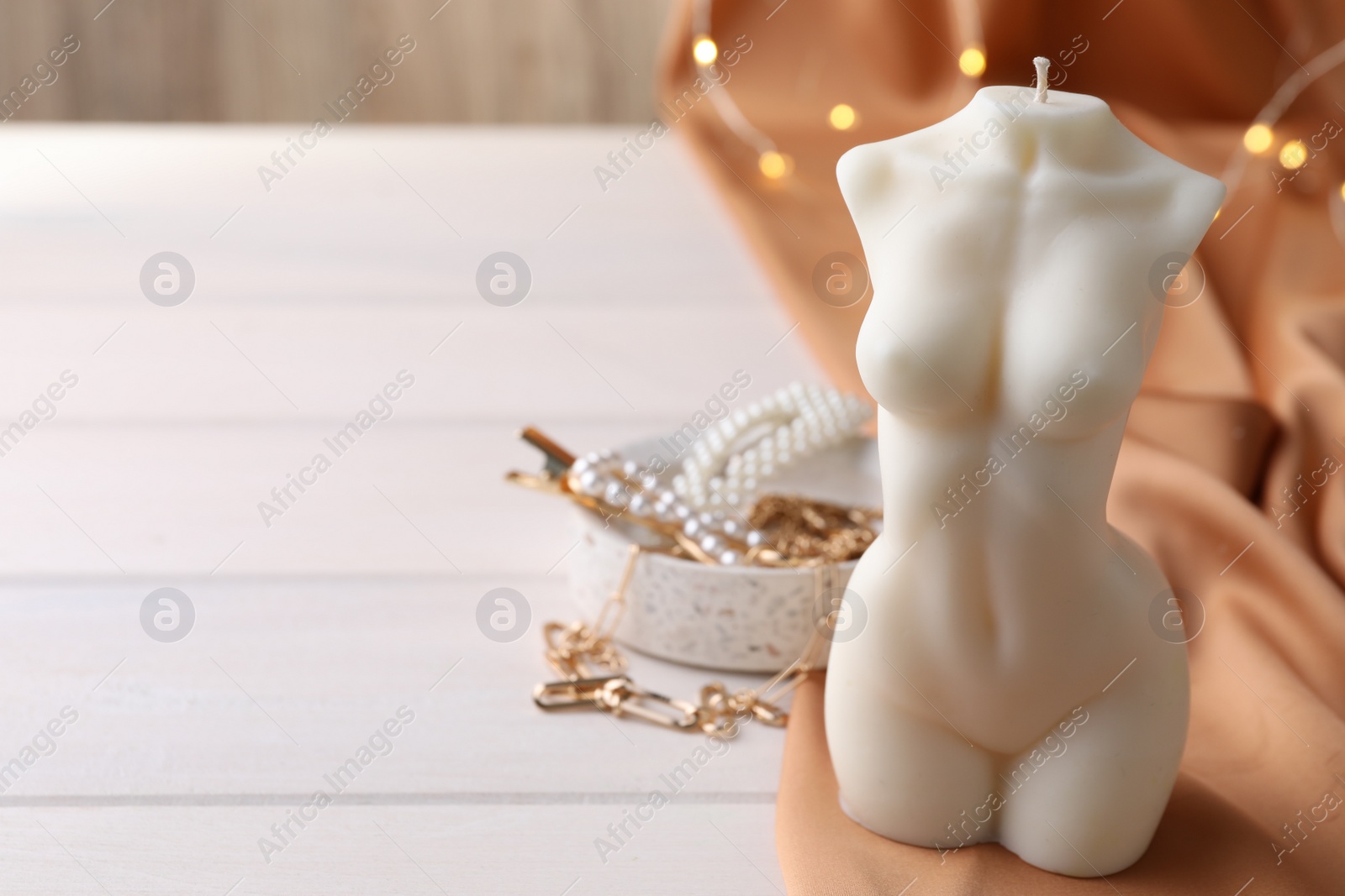 Photo of Composition with beautiful female body shaped candle on white table. Space for text