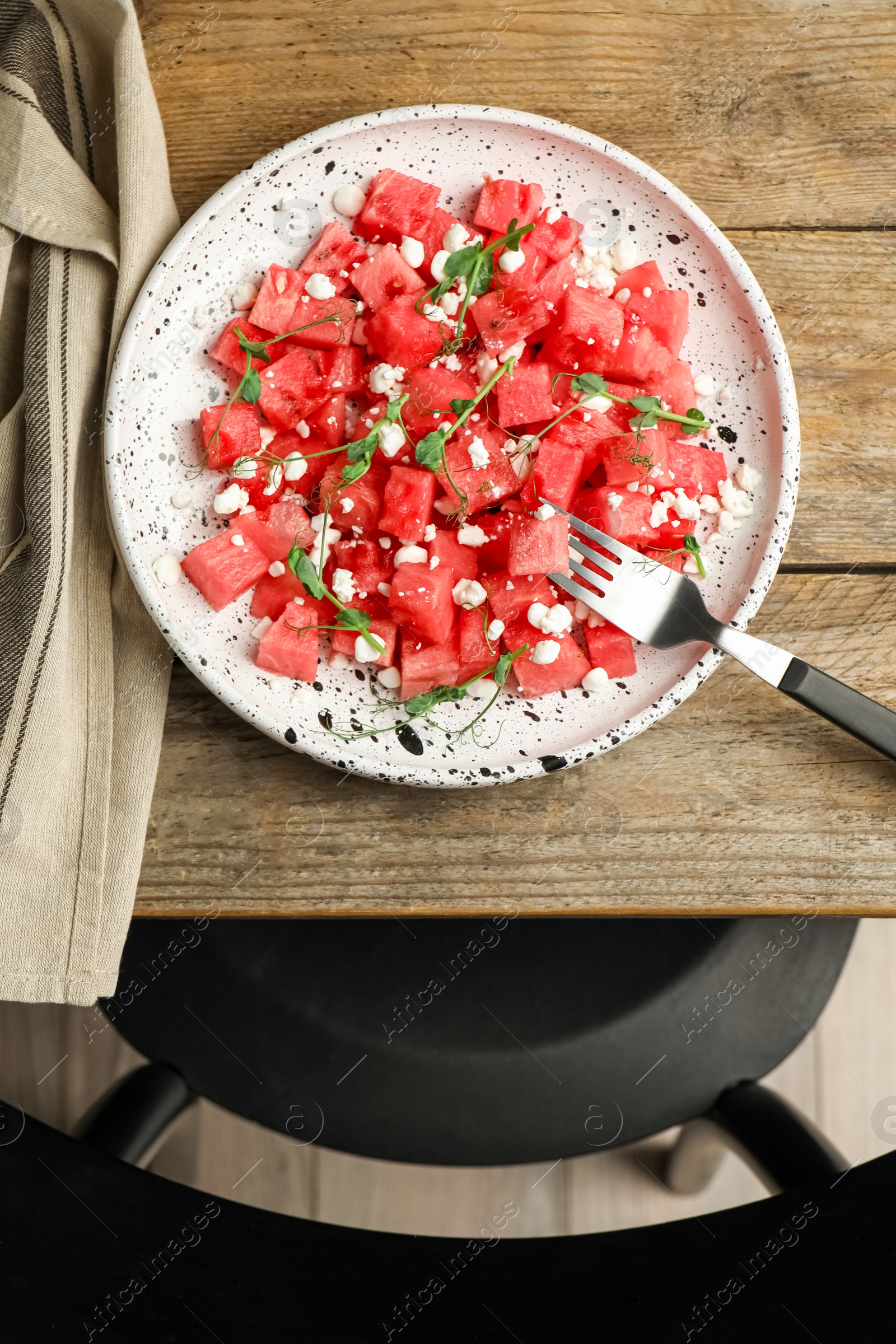 Photo of Delicious salad with watermelon served on wooden table indoors, flat lay