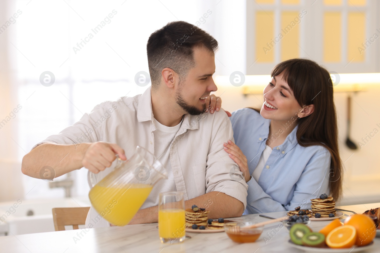 Photo of Happy couple having tasty breakfast at home