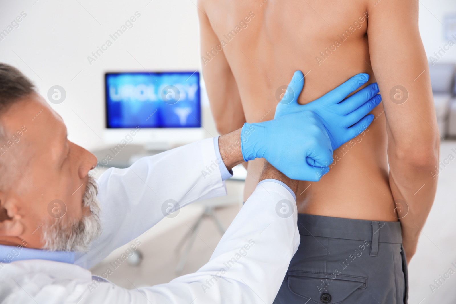 Photo of Urologist in gloves examining young patient in clinic