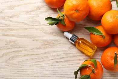 Bottle of tangerine essential oil and fresh fruits on white wooden table, flat lay. Space for text