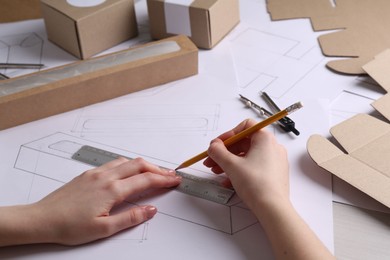 Photo of Woman creating packaging design at table, closeup