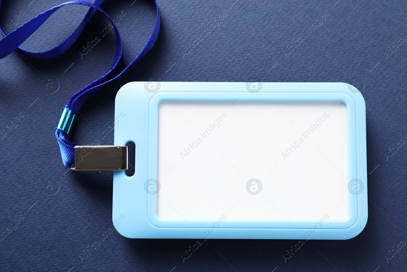 Photo of Blank badge with string on blue background, top view