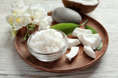 Photo of Glass bowl with natural coconut scrub on wooden tray