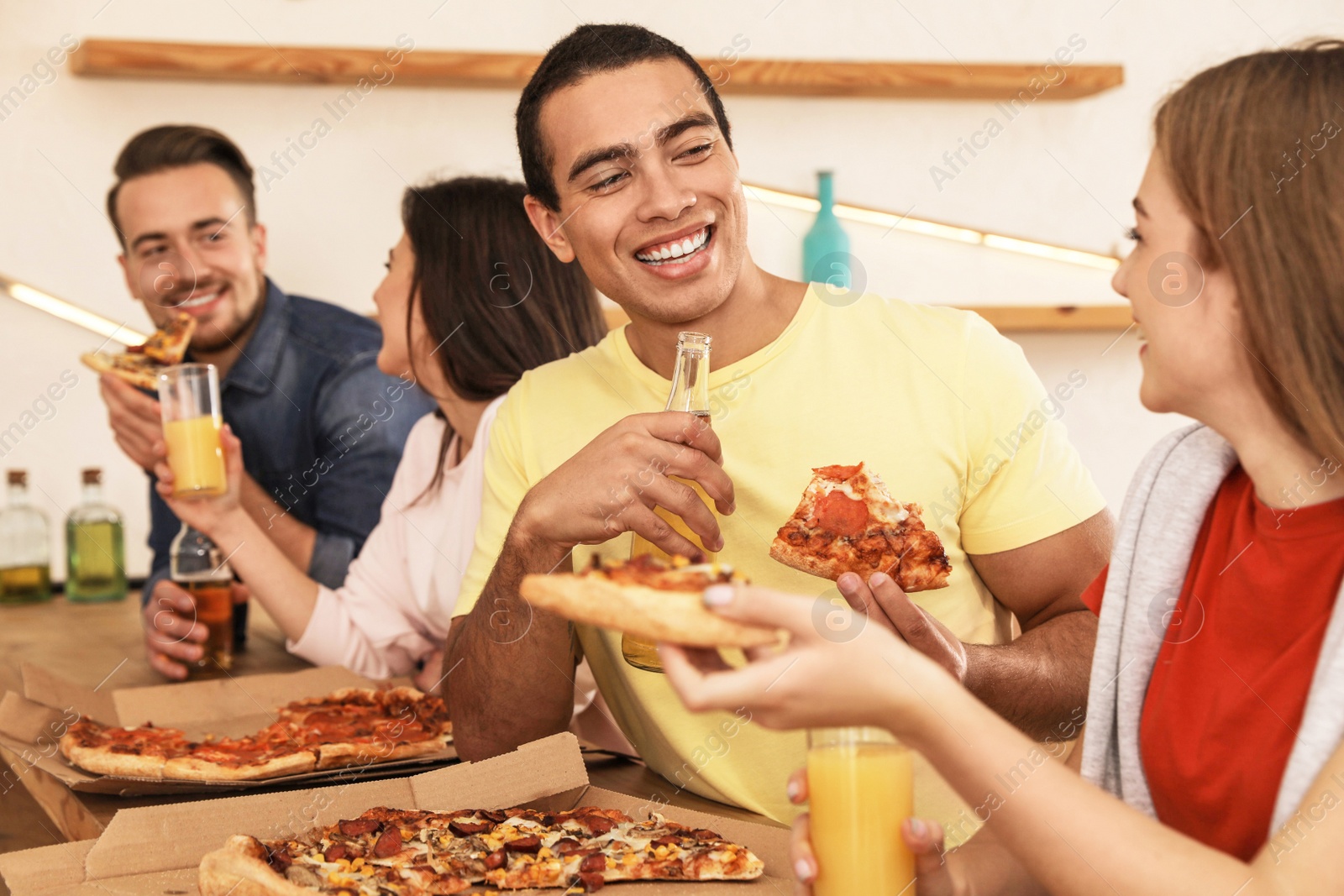 Photo of Group of friends having fun party with delicious pizza in cafe