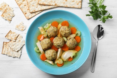 Flat lay composition with Jewish matzoh balls soup on white wooden table