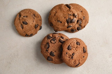 Photo of Tasty chocolate chip cookies on light background, top view