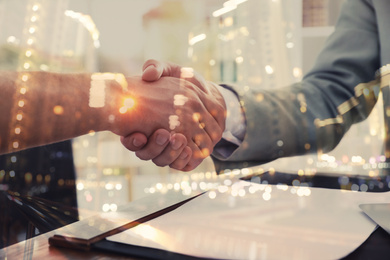 Image of Double exposure of partners shaking hands and night cityscape, closeup. Business corporation 