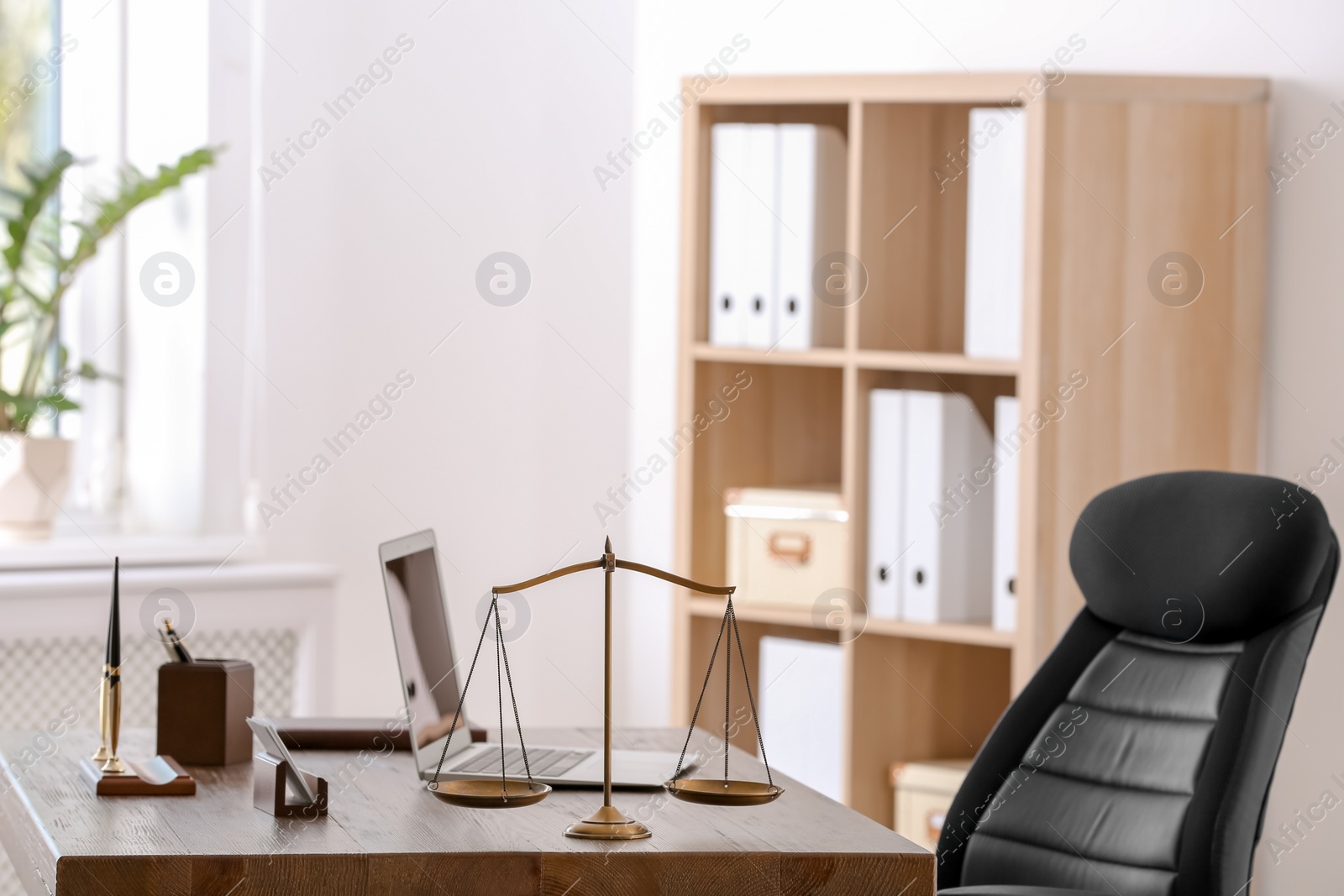 Photo of Table with scales of justice in lawyer's office