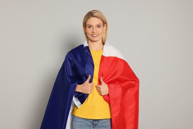 Woman with flag of France on light grey background