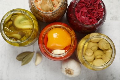 Photo of Many jars with different preserved products on white table, flat lay