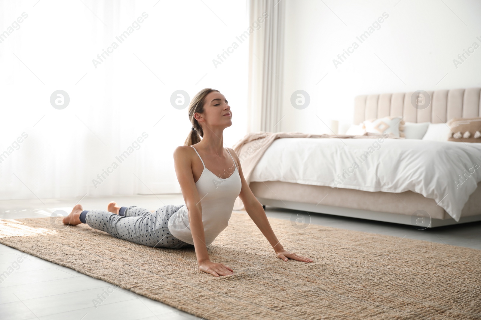 Photo of Young woman doing gymnastics on floor at home. Morning fitness