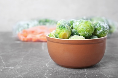 Photo of Bowl with frozen brussel sprouts on table. Vegetable preservation