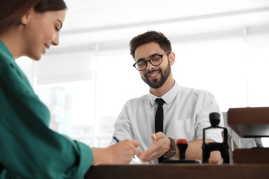 Male notary working with client in office