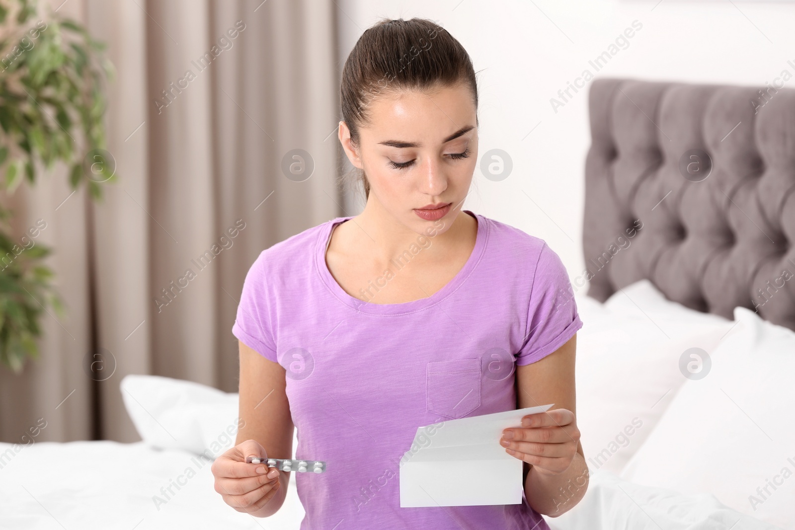 Photo of Beautiful young woman with pills at home