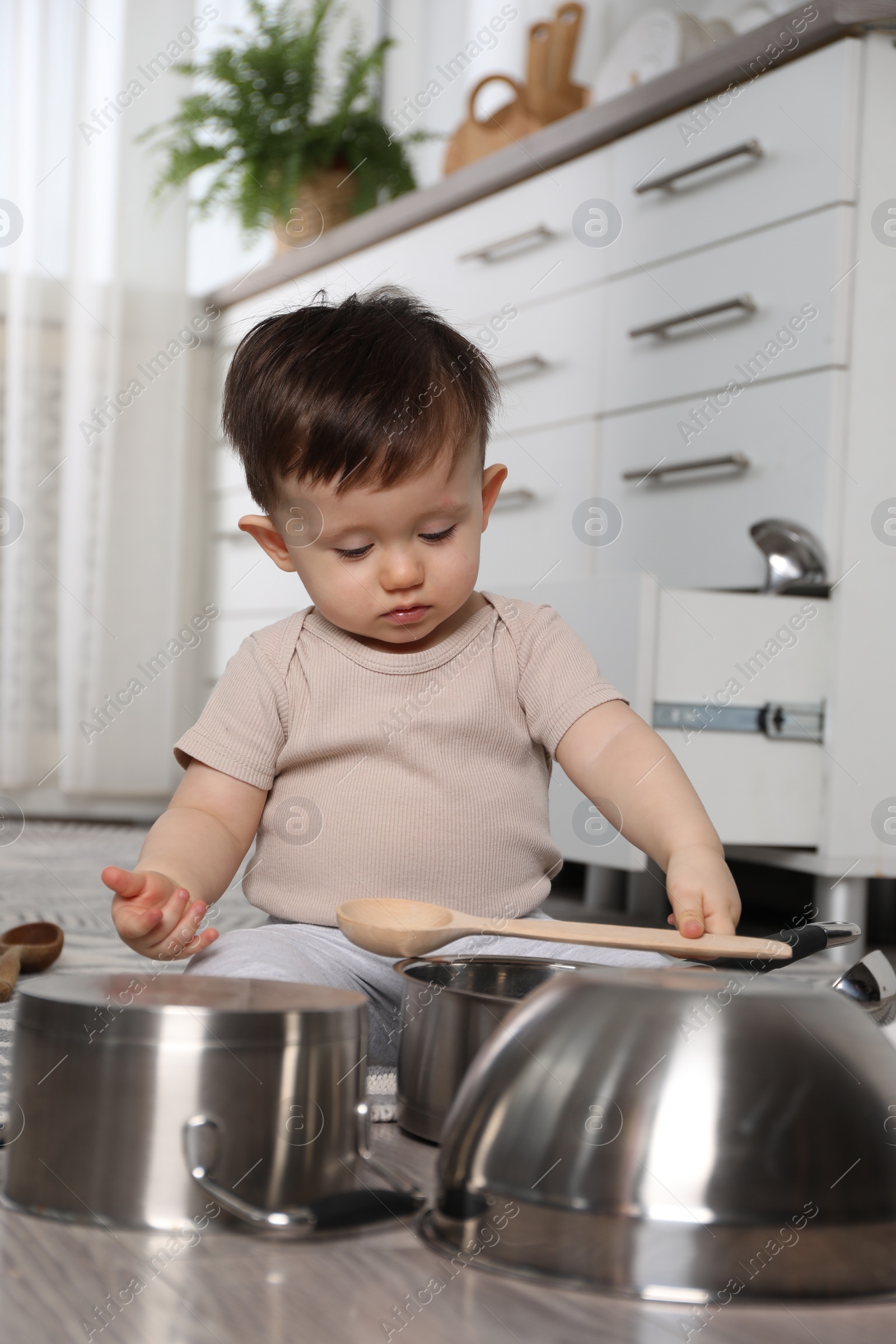 Photo of Cute little boy with cookware at home