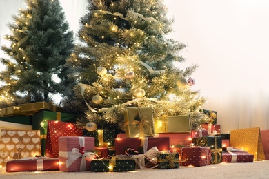 Photo of Many different gifts under Christmas tree indoors