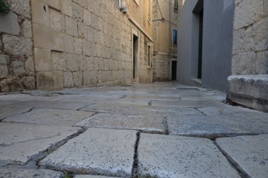 Photo of Empty paved alleyway between residential buildings in town