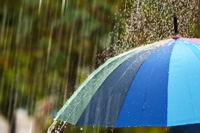 Photo of Person with bright umbrella under rain on street, closeup