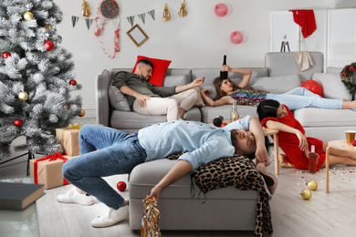 Friends suffering from hangover in messy room after New Year party
