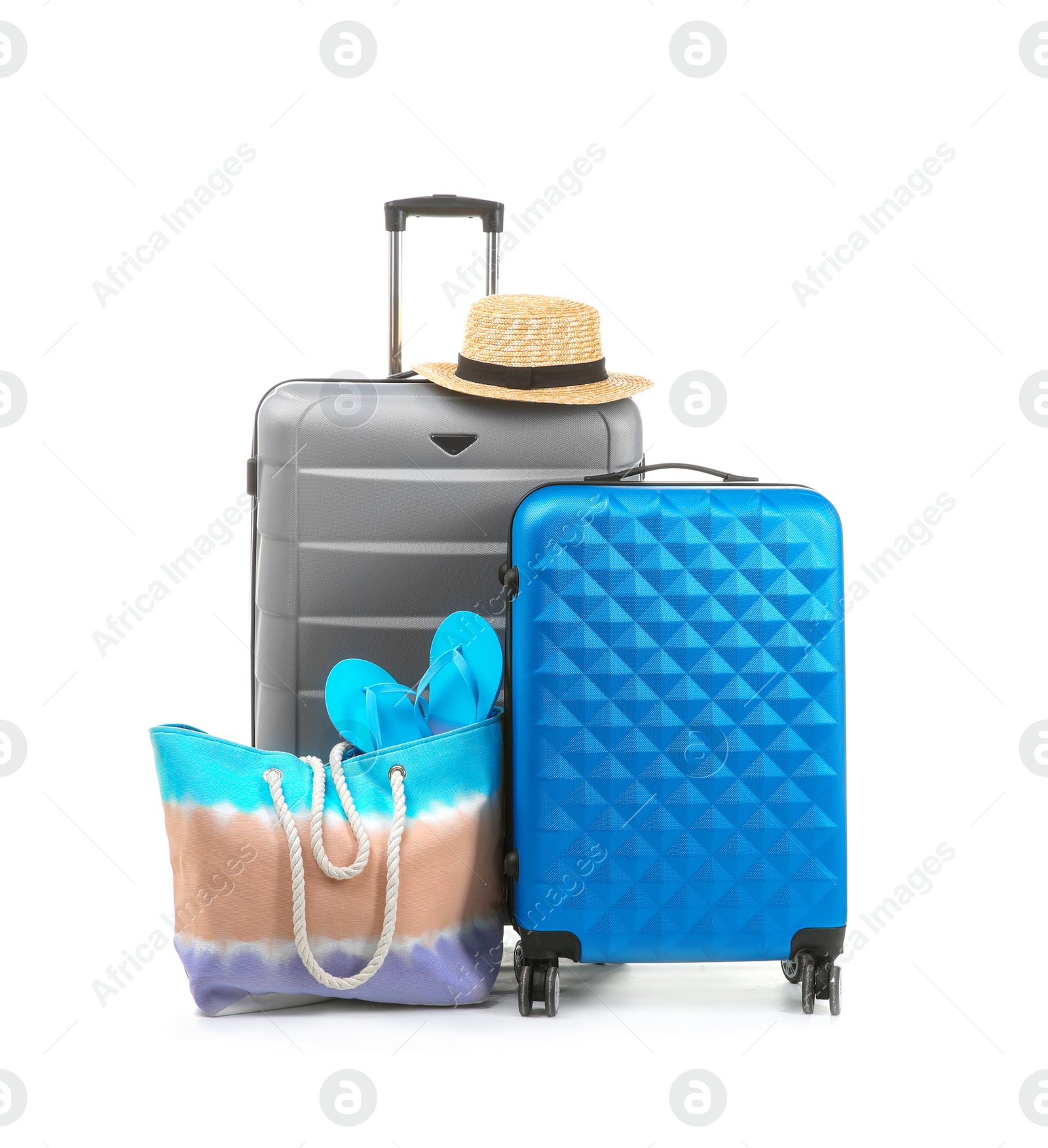 Photo of Packed suitcase with hat and hand-luggage on white background