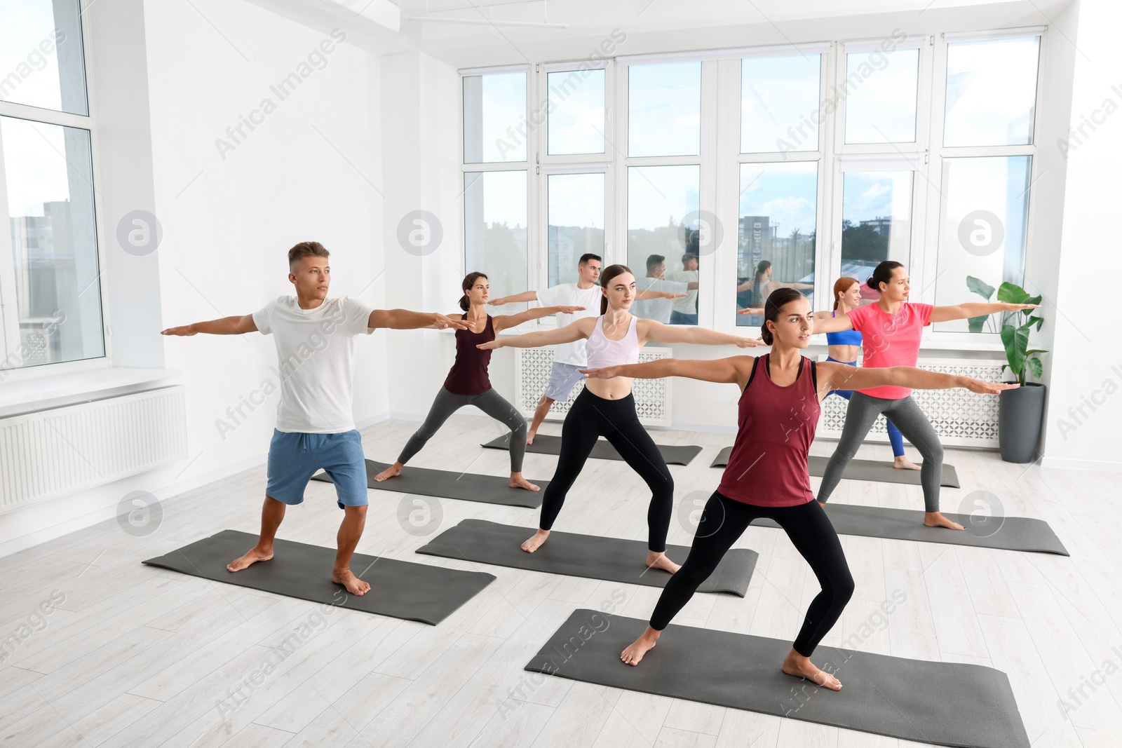 Photo of Group of people practicing yoga on mats indoors