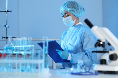 Photo of Scientist with clipboard working in laboratory. Medical research
