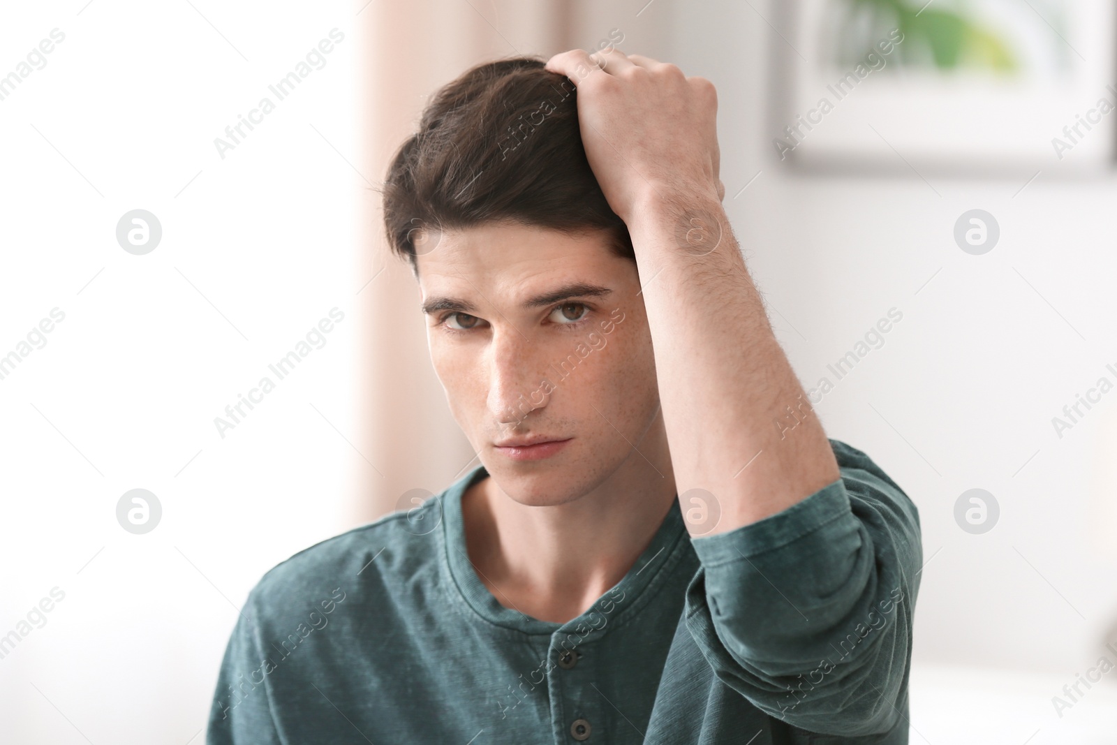 Photo of Portrait of young man with beautiful hair indoors