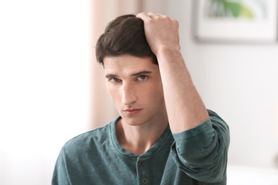 Portrait of young man with beautiful hair indoors