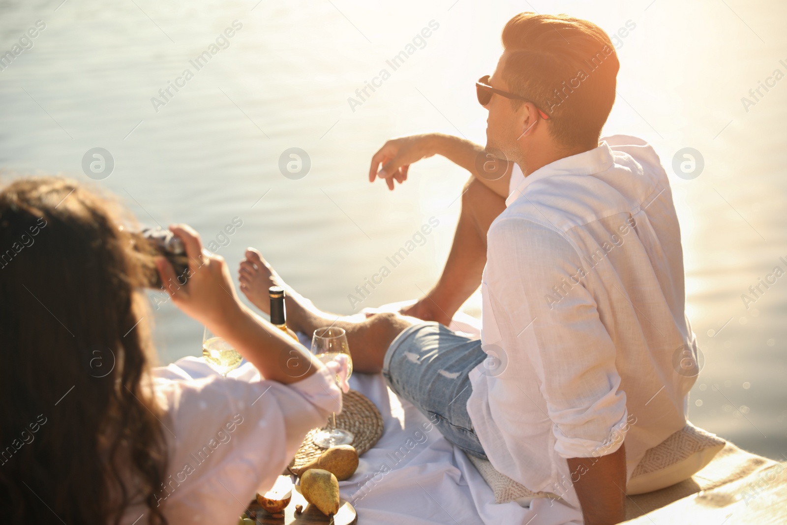 Photo of Woman taking picture of boyfriend on pier at picnic