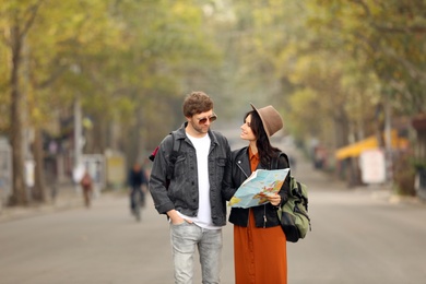 Photo of Coupletravelers with map on city street