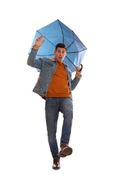 Emotional man with umbrella caught in gust of wind on white background