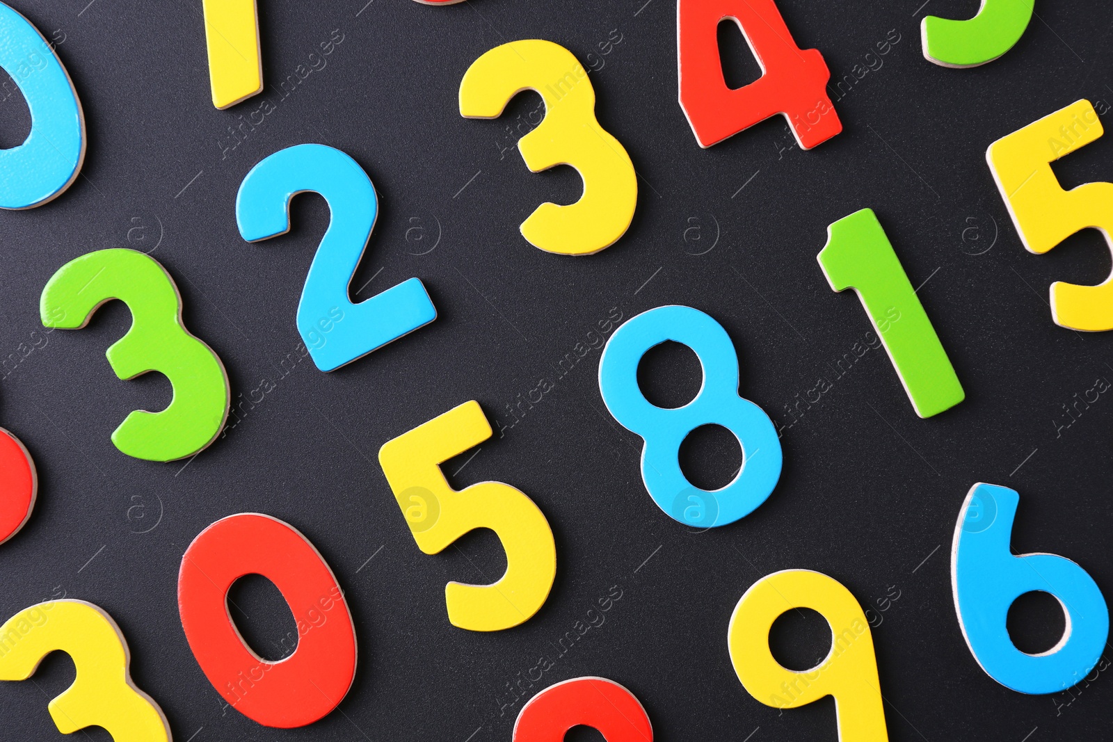 Photo of Colorful numbers on black background, flat lay